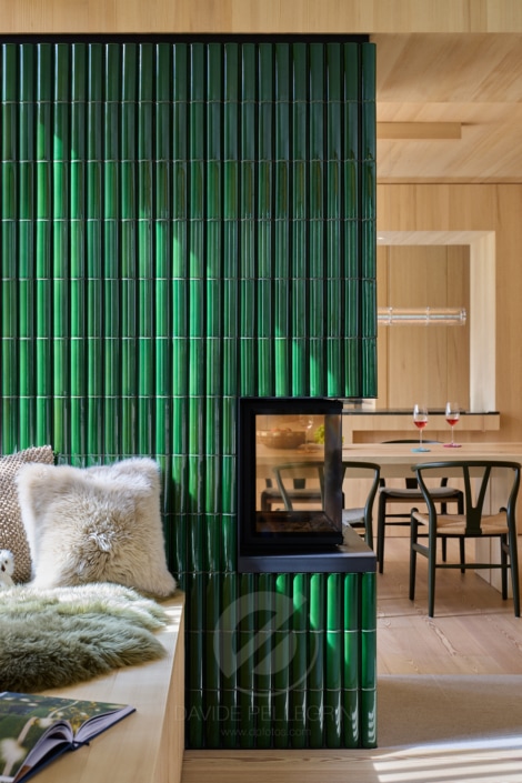 Un reportaje arquitectónico de una casa bávara con paredes de madera y una chimenea verde.