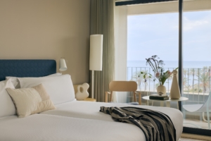 Una cama en una habitación con vista al mar.
