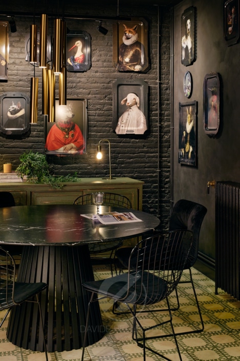 Un comedor con una mesa y sillas negras, maravillosamente captado por un talentoso fotógrafo de diseño de interiores especializado en renovaciones.
