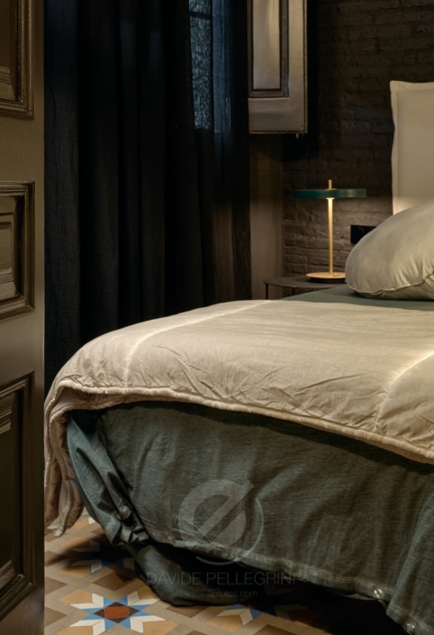 Una cama acogedora en un dormitorio elegantemente renovado, capturada por un talentoso fotógrafo especializado en diseño de interiores.