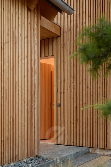 Un reportaje fotográfico de una casa de madera con una puerta de madera.