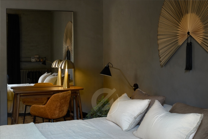 Un dormitorio interior con una cama y un espejo, perfecto para un fotógrafo que busca capturar la belleza de una renovación del diseño de interiores.
