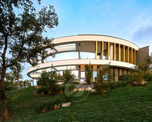 Una casa moderna de forma circular en lo alto de una colina, mostrando la elegancia de Villa Camiral.