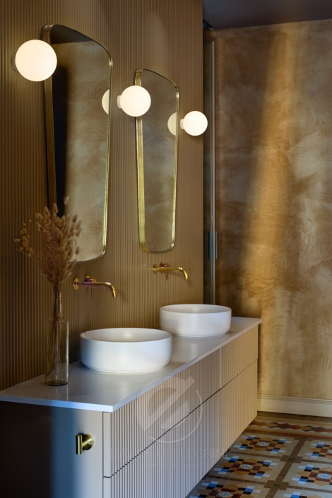 Un baño con dos lavabos, espejo y un interiorismo moderno.